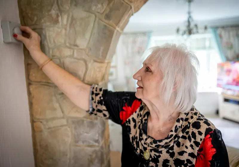 Person adjusting a thermostat